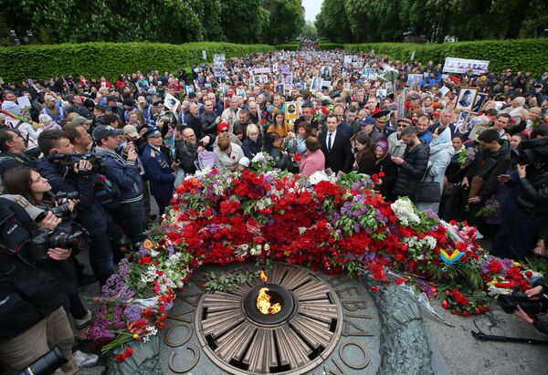 Участники акции Бессмертный полк возлагают цветы к Вечному огню в киевском парке Славы