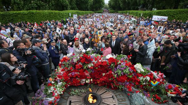 Участники акции Бессмертный полк возлагают цветы к Вечному огню в киевском парке Славы