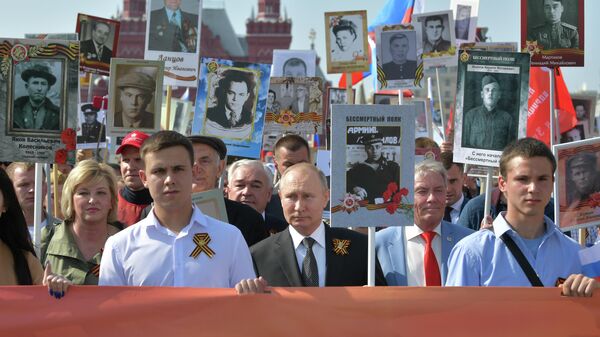 Президент РФ Владимир Путин с портретом своего отца-фронтовика на акции Бессмертный полк в 2019 году