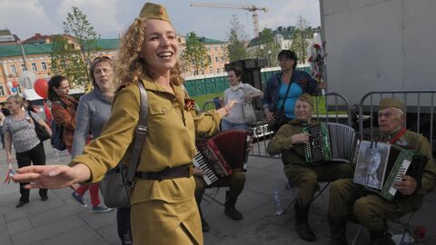 Девушка танцует под гармонь во время празднования Дня Победы в Москве