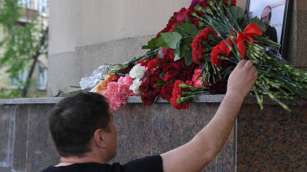 Мужчина возлагает цветы к зданию редакции Говорит Москва в память о главном редакторе радиостанции Сергее Доренко