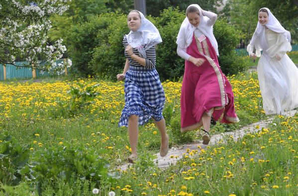 Девушки, бегущие в сарафанах и платках в день праздника Святых Жён-Мироносиц в духовном центре старообрядчества Рогожская слобода в Москве