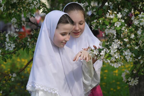 Девочки в платках возле цветущего дерева в день праздника Святых Жён-Мироносиц в духовном центре старообрядчества Рогожская слобода в Москве