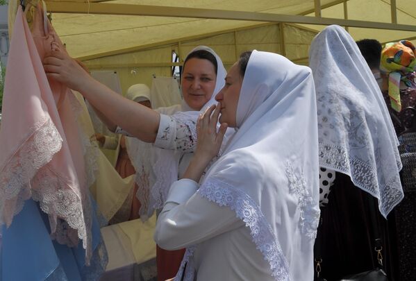 Женщина выбирает платок в день праздника Святых Жён-Мироносиц в духовном центре старообрядчества Рогожская слобода в Москве
