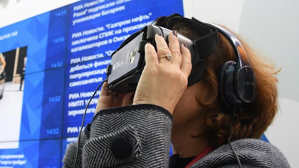 Генеральный директор ГТГ Зельфира Трегулова тестирует очки виртуальной реальности Gear VR на стенде МИА Россия Сегодня на Российском инвестиционном форуме в Сочи