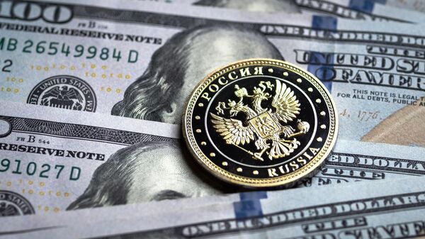Купюры американских долларов и монета с гербом Российской Федерации