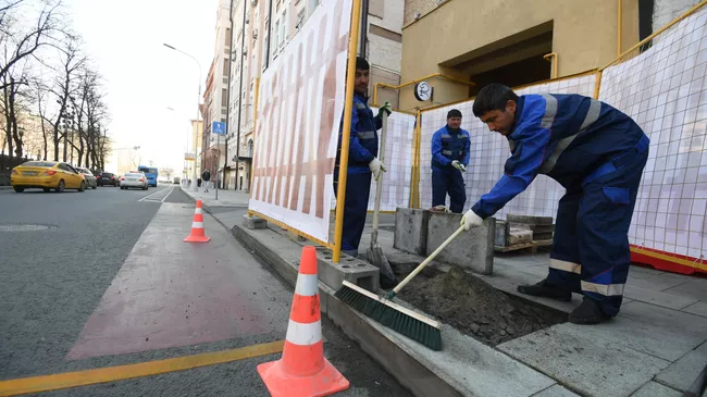 Рабочие укладывают тротуарную плитку на Никитском бульваре в Москве