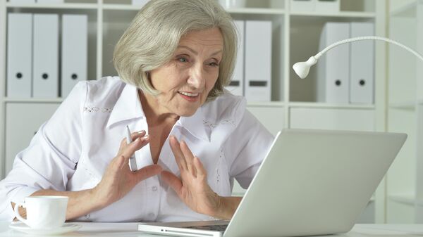 Пожилая женщина работает на ноутбуке