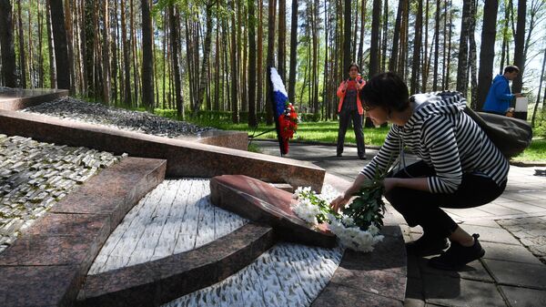 Девушка возлагает цветы к памятнику в мемориальном комплексе Медное в Тверской области