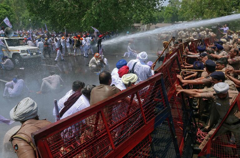 Полиция поливает водой демонстрантов во время акции протеста в индийском Чандигархе 