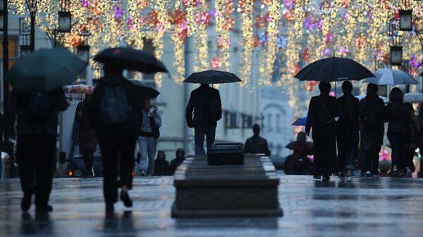 Прохожие на одной из московских улиц во время дождя. Архивное фото