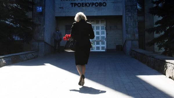 Женщина с цветами идет на церемонию прощания с главным редактором радиостанции Говорит Москва Сергеем Доренко