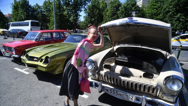 Девушка у автомобиля ГАЗ-21 Волга на выставке классических ретро-автомобилей в Москве