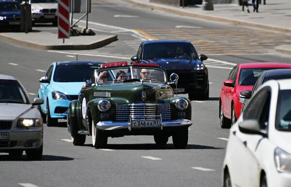 Участники в автомобиле Cadillac Sixty two Convertible 1940 года принимают участие в ралли классических ретро-автомобилей в Москве