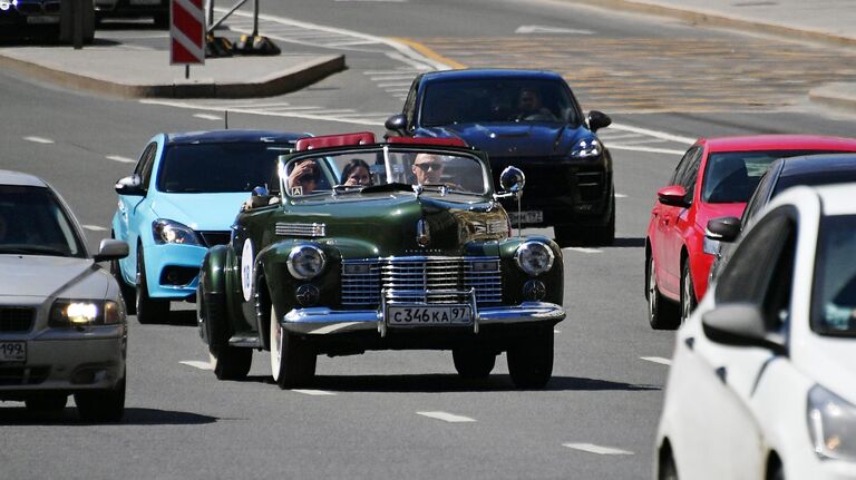 Участники в автомобиле Cadillac Sixty two Convertible 1940 года принимают участие в ралли классических ретро-автомобилей в Москве