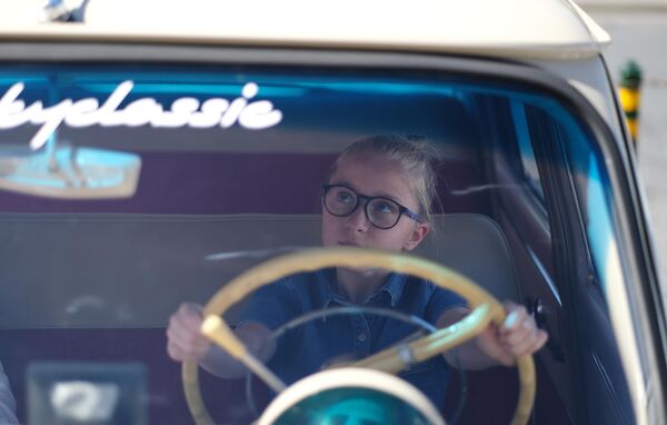 Девочка в ретро автомобиле, который принимает участие в ралли классических ретро-автомобилей в Москве