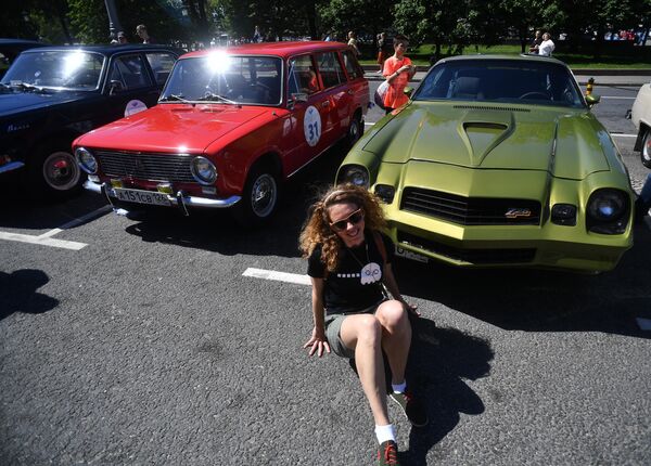 Девушка у автомобиля Chevrolet Camaro Z28 (1975-1979 гг. выпуска), который принимает участие в ралли классических ретро-автомобилей в Москве