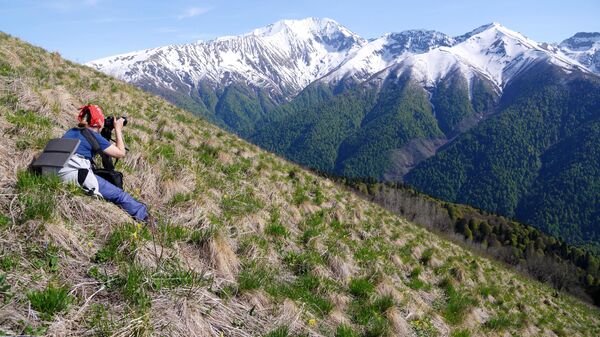Девушка фотографирует пейзажи Кавказского государственного природного биосферного заповедника имени Х. Г. Шапошникова