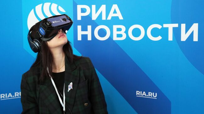 Девушка использует VR очки на стенде МИА Россия сегодня на Russian Tech Week - 2019 в технопарке Сколково