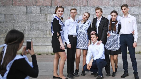 Выпускники средних школ фотографируются после празднования последнего звонка на Михайловской набережной в Новосибирске.