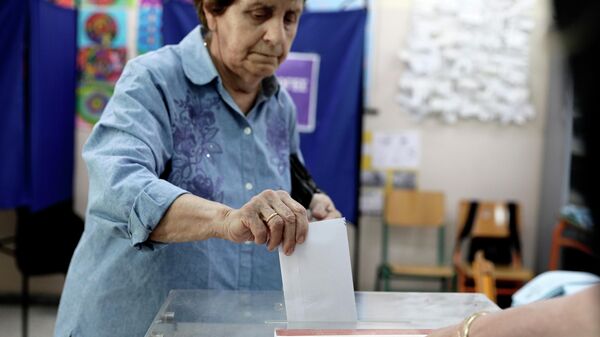 Женщина во время голосования на одном их избирательных участков в Афинах. Архивное фото