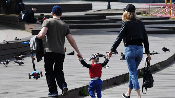 Семейная пара с ребенком гуляет по набережной