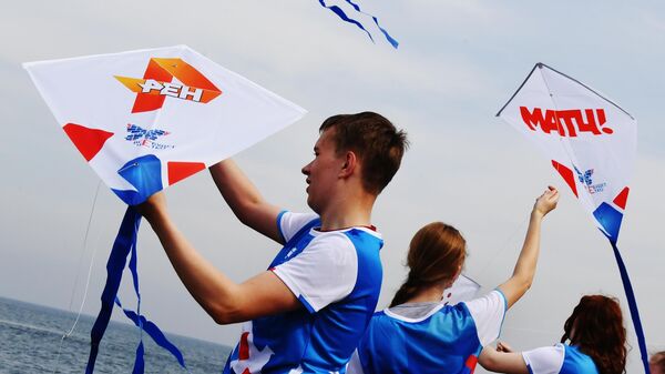 Участники акции запускают воздушных цифровых змеев с логотипами телеканалов во Владивостоке 