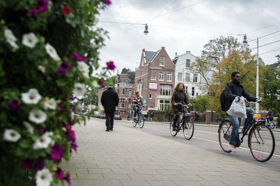 Горожане едут на велосипедах по одной из улиц в центре Амстердама