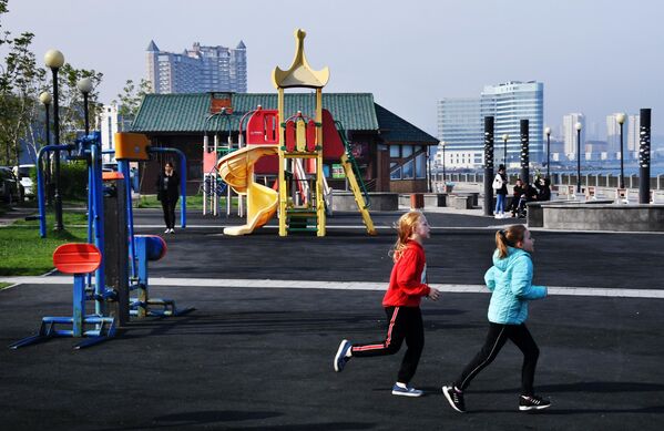 Дети бегают по детской площадке на набережной Спортивной гавани во Владивостоке