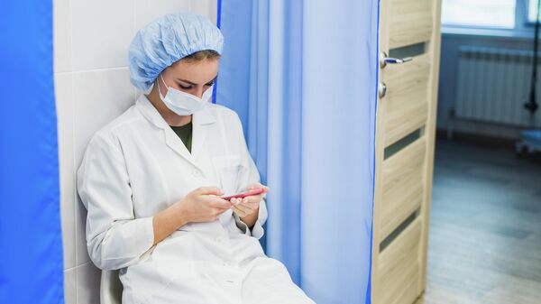 Медсестра с мобильным телефоном во время перерыва. Иллюстративное изображение. 