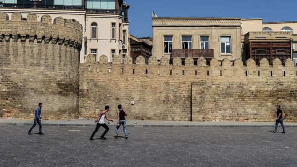 Молодые люди играют в футбол в Ичери-шехер (Старом городе) в Баку