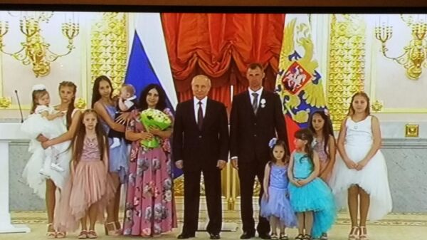 Президент РФ Владимир Путин во время награждения орденами Родительская слава в Александровском зале Кремля. 30 мая 2019 года. Фото с экрана телевизора, установленного в комнате для журналистов.