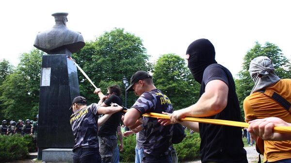 Представители националистических организаций с помощью троса пытаются повалить бюст маршала Георгия Жукова в Харькове возле Дворца спорта. 2 июня 2019