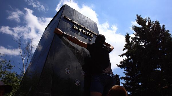 Представители националистических организаций сбивают надпись под бюстом маршала Георгия Жукова в Харькове возле Дворца спорта