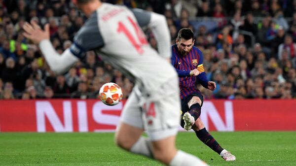 Форвард Барселоны Лионель Месси забивает мяч в ворота Ливерпуля
