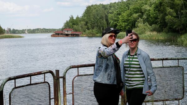 Туристы делают селфи в речном порту заброшенного города Припять, недалеко от Чернобыльской АЭС, Украина  