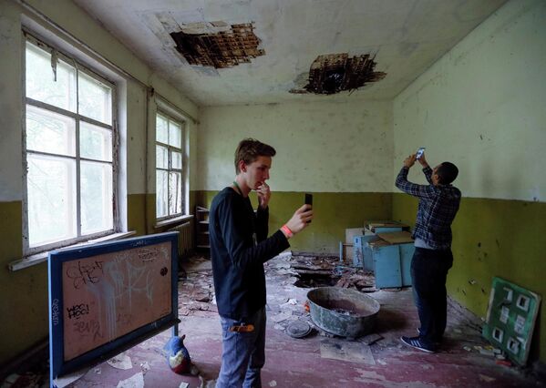 Туристы фотографируются в детском саду в заброшенном поселке Копачи, недалеко от Чернобыльской АЭС, Украина