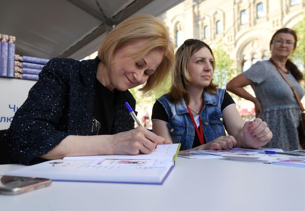 Писательница Дарья Донцова дает автографы во время ежегодного российского книжного фестиваля на Красной площади