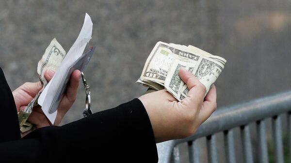 Женщина расплачивается наличными в Нью-Йорке 