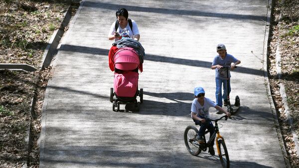 Женщина гуляет с детьми в парке 