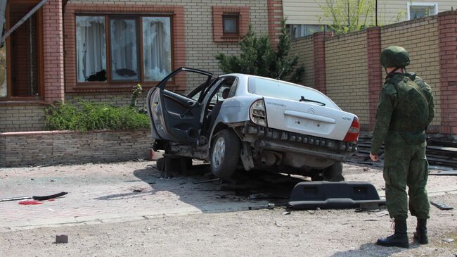 Военнослужащий ДНР у автомобиля, поврежденного в результате артиллерийского обстрела города Докучаевск Донецкой области