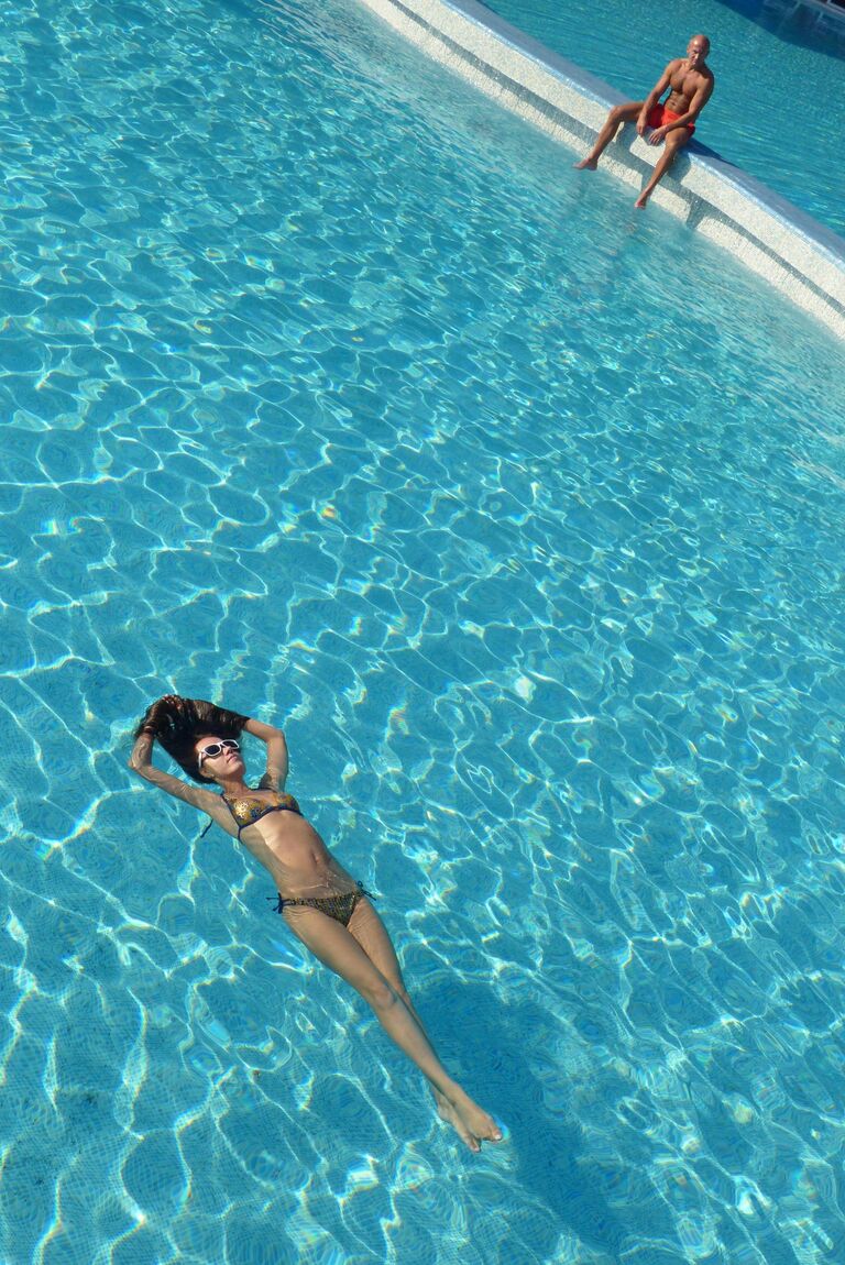 Девушка плавает в бассейне одного из отелей Антальи Девушка плавает в бассейне одного из отелей Антальи