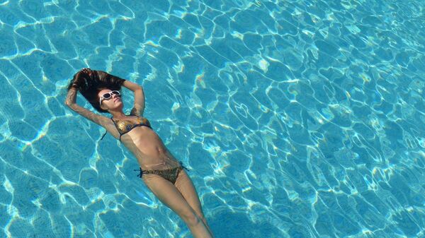 Девушка плавает в бассейне одного из отелей Антальи