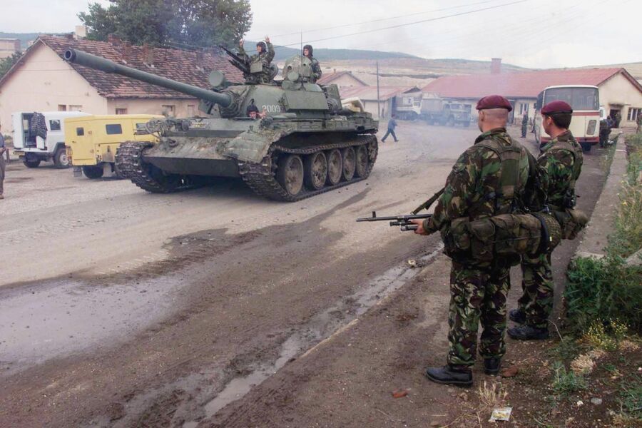 Сербский танк T55 проезжает мимо олдат 1-й воздушно-десантной дивизии Великобритании по дороге к аэропорту Приштины 