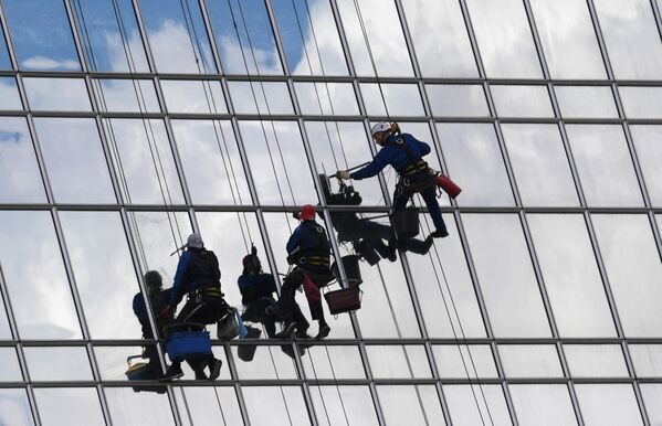 Промышленные альпинисты моют фасад высотного здания в Москве