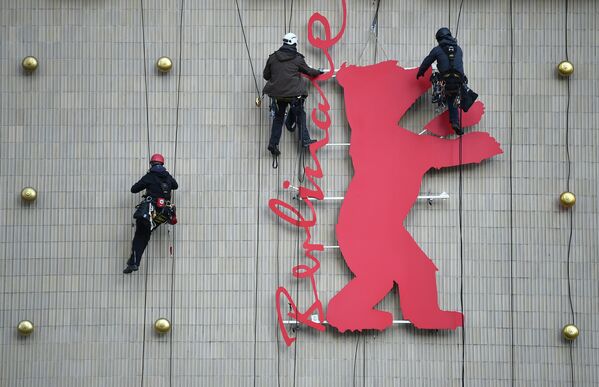 Промышленные альпинисты устанавливают фигуру медведя на кинотеатре в Берлине