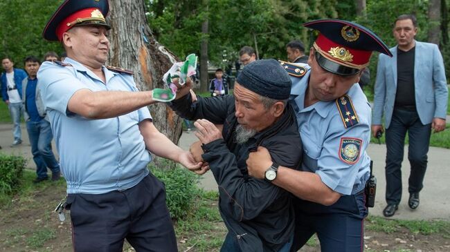 Сотрудники полиции задерживают участника несанкционированного митинга  в день проведения выборов президента Казахстана в Алма-Ате. 9 июня 2019