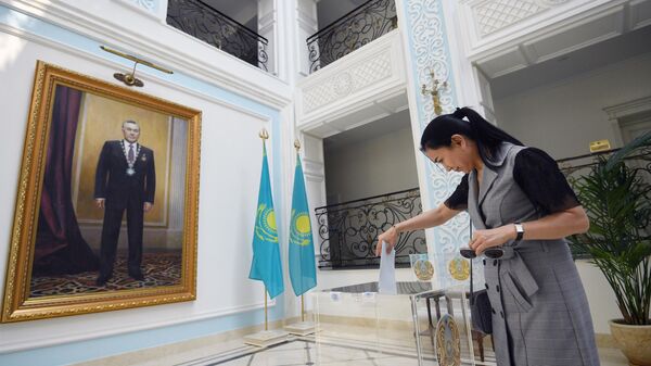 Женщина голосует на внеочередных выборах президента Казахстана в посольстве Казахстана в Москве. 9 июня 2019