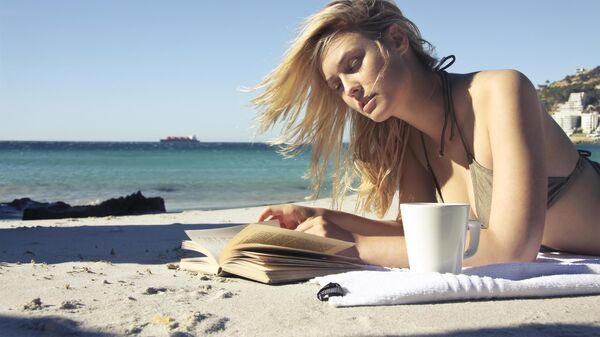 Девушка читает на пляже