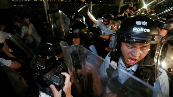 Полиция оттесняет демонстрантов во время акции протеста в Гонконге
